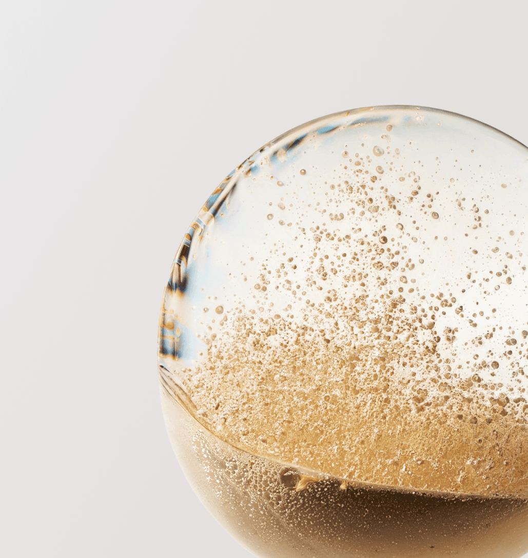 Glass sphere with golden particles in liquid